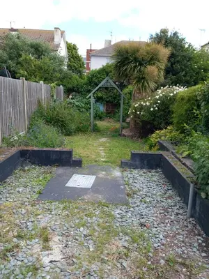 a backyard with a garden with a gate and plants at Beach palace in Clacton-on-Sea