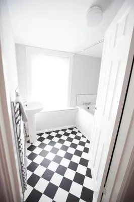 a bathroom with a black and white checkered floor at Beach palace in Clacton-on-Sea