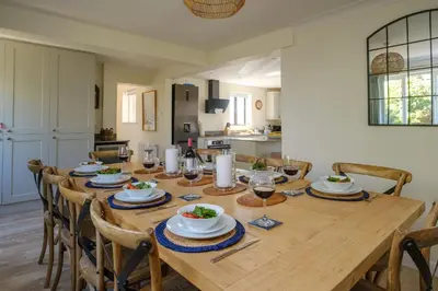 a dining room with a wooden table with glasses of wine at 9 The Coastguards in Thorpeness