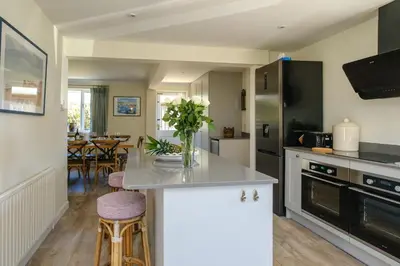 a kitchen with a counter with a vase of flowers on it at 9 The Coastguards in Thorpeness