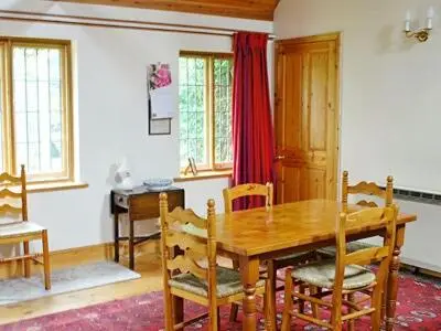 a dining room with a wooden table and chairs at Netherall Manor Lodge in Soham