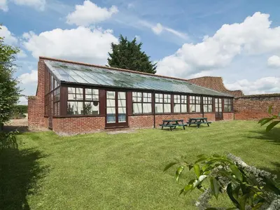 a brick building with a picnic table in a yard at St Andrews Barn in Necton