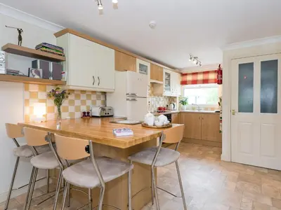 a kitchen with a wooden table and bar chairs at Jubileum Lodge Uk27999 in Watton