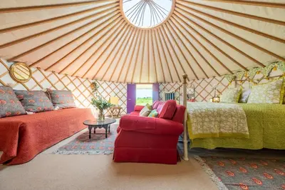 a yurt with a bed and a couch and a chair at Luxury glamping in Constable Country - Valley View Yurt in Edwardstone
