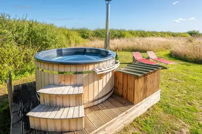 a hot tub and two chairs on a wooden deck at Luxury glamping in Constable Country - Valley View Yurt in Edwardstone