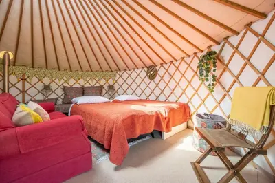 a room with a bed and a couch in a yurt at Luxury glamping in Constable Country - Valley View Yurt in Edwardstone