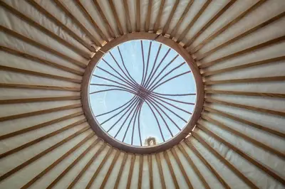a round window in a wooden wall with a round ceiling at Luxury glamping in Constable Country - Valley View Yurt in Edwardstone