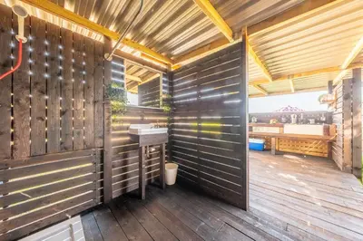 a bathroom with a sink and a wooden wall at Luxury glamping in Constable Country - Valley View Yurt in Edwardstone