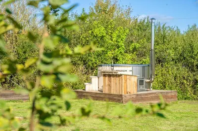 a wooden box in a field with trees at Luxury glamping in Constable Country - Valley View Yurt in Edwardstone