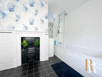 a bathroom with a fireplace with blue and white wallpaper at Fisherman's Cottage - Harwich Breaks - BRAND NEW - long stays available great prices - get in touch for all bookings - cottage in harwich - beach stay in Harwich