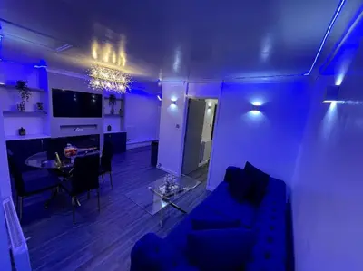 a blue living room with a couch and a table at Chic 2 Bedroom Flat in Trimley Heath