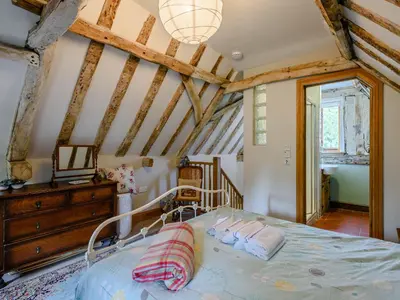 a bedroom with a bed and a wooden ceiling at The Old Bike Shop in Brockdish