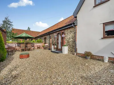 an external view of a house with a patio at Pear Tree Cottage in Banham