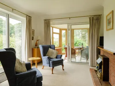 a living room with two chairs and a fireplace at Covert Cottage in Gasthorpe