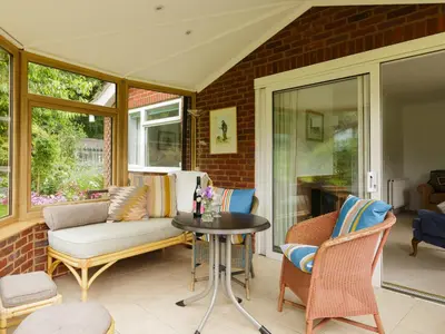 a screened porch with a couch and a table at Covert Cottage in Gasthorpe