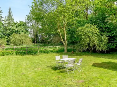 a table and chairs in the grass in a yard at Oaklawn Cottage in Eye