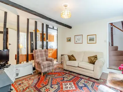 a living room with a couch and a tv at Oaklawn Cottage in Eye