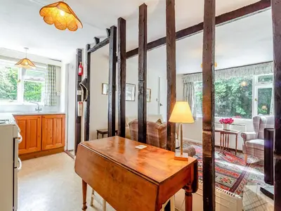 a kitchen and living room with a wooden desk in a room at Oaklawn Cottage in Eye