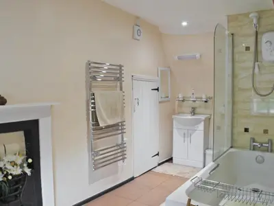 a bathroom with a tub and a shower and a sink at The Old House in Mellis