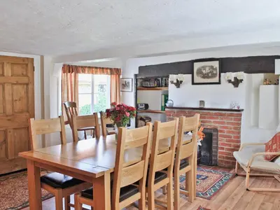 a dining room with a table and a fireplace at The Old House in Mellis