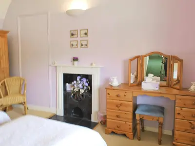 a bedroom with a bed and a dresser and a mirror at The Old House in Mellis