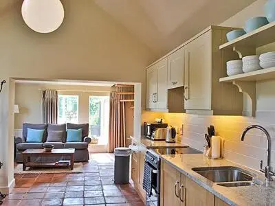 a kitchen with a sink and a couch in a room at The Granary in Stuston