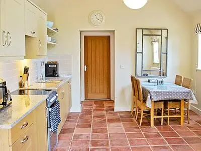 a kitchen with a table and a dining room at The Granary in Stuston
