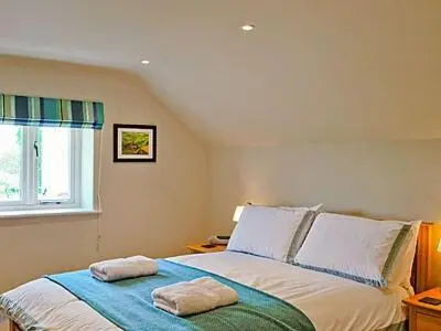 a bedroom with a bed with two towels on it at The Granary in Stuston