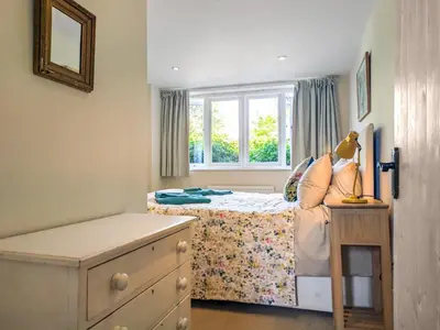 a small bedroom with a bed and a window at Dove Cottage in Halesworth