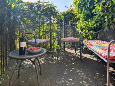 a table with a bottle of wine and a bowl of fruit at Dove Cottage in Halesworth