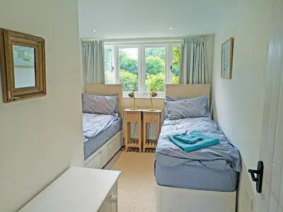 a small room with two beds and a window at Dove Cottage in Halesworth