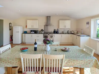 a kitchen with a table with a bottle of wine at Dove Cottage in Halesworth