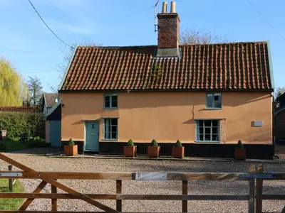 a house with potted plants in front of it at Bell Corner Cottage in Cratfield