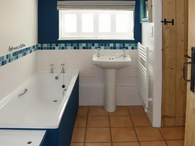 a bathroom with a sink and a bath tub and a sink at Bell Corner Cottage in Cratfield