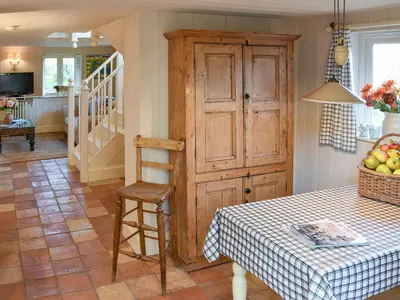 a dining room with a table and a wooden cabinet at Swallows Nest in Saint Lawrence