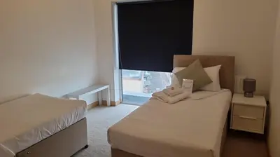 a bedroom with a bed and a large window at Modern 2 bed flat with balcony in Southend-on-Sea