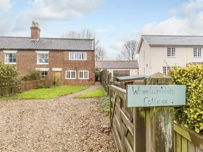 a sign on a fence in front of a house at Wheelwrights Cottage in Rumburgh