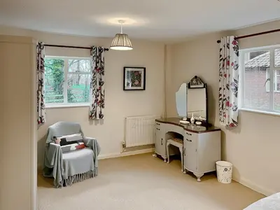 a bedroom with a desk and a chair and a mirror at The Cottage in Fressingfield