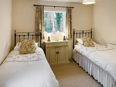 two twin beds in a room with a window at The Cottage in Fressingfield