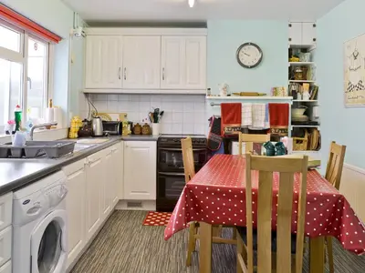 a kitchen with a table with a red table cloth at Heath View Cottage in Westleton