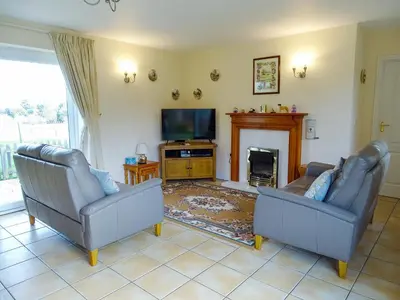 a living room with two couches and a tv at Meadow View in Leiston