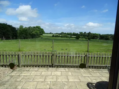 a view of a field through a fence at Meadow View in Leiston