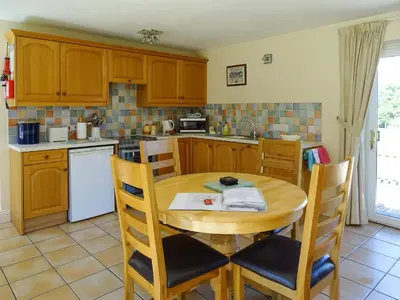 a kitchen with a wooden table and chairs in a kitchen at Meadow View in Leiston
