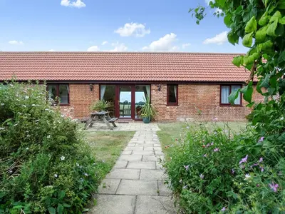 a brick house with a pathway in front of it at Meadow View in Leiston