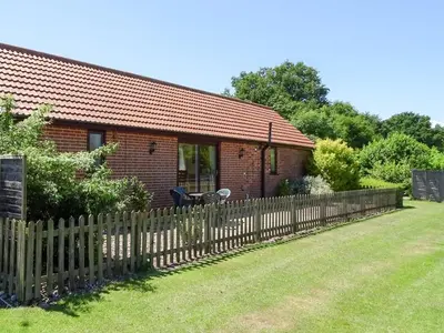 a wooden fence in front of a house at Meadow View in Leiston