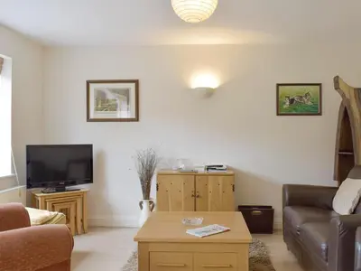 a living room with a couch and a tv at Dormers in Leiston