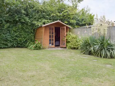 a small wooden shed in a yard at Dormers in Leiston