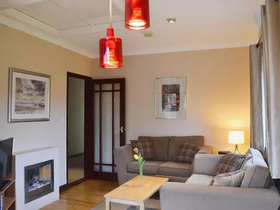 a living room with a couch and a table at Boundary Gallery Cottage in Framlingham