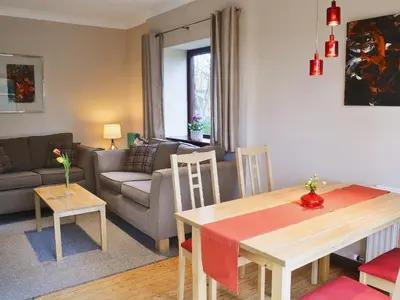 a living room with a table and a couch at Boundary Gallery Cottage in Framlingham