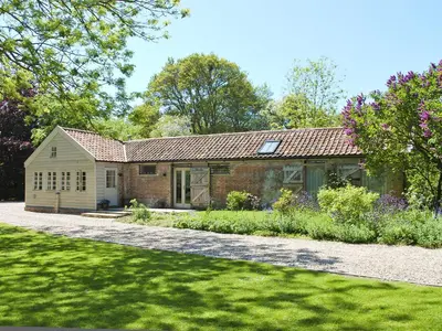 a brick house with a garden in front of it at The Coach House in Saxmundham